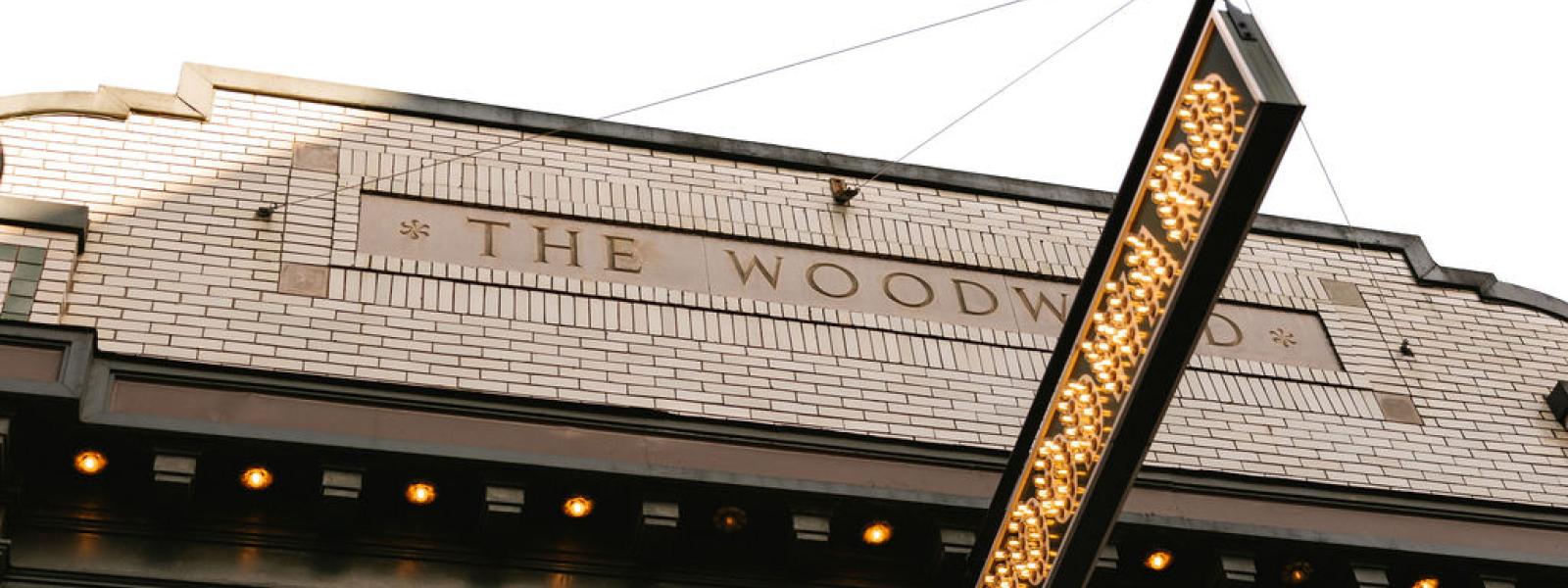 An image of the woodward theater with the sign lit up.